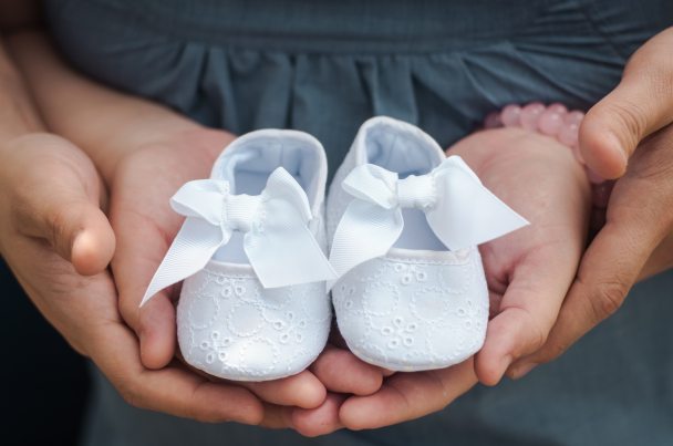 person-carrying-pair-of-baby-s-white-flats-754953